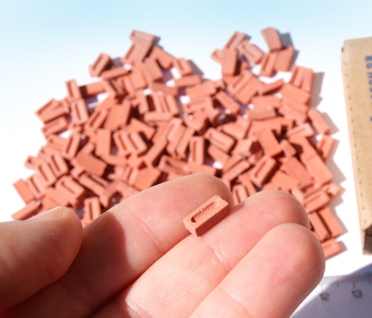 200 pieces of red 1:24 G scale bricks, made by naaron88, for model sceneries and dollhouse dioramas, shown on hand.